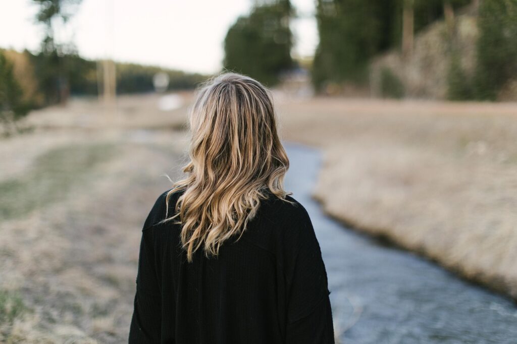 Femme seule de dos en quête de sérénité – Retrouver l’équilibre mental grâce à une nutrition adaptée au cerveau